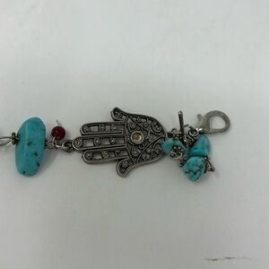 Fatima's hand bracelet with silver-colored turquoise stones and red Stones.